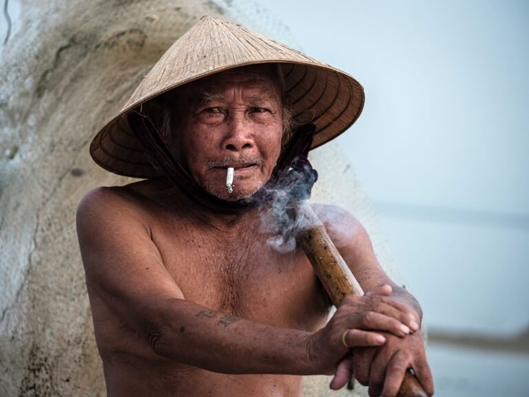 Fisherman Smoking and Carrying a Net in Tam Giang Lagoon