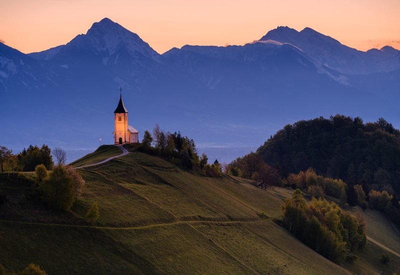 Jamnik church of St. Primus and Felician on a hilltop with the Kamnik-Savinja Alps at sunrise, Slovenia